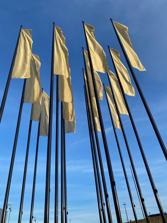 Flera svarta flaggstänger med gul flagga