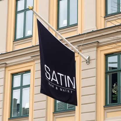 Fasadflaggstång med svart flagga som sitter på ett gammalt hus 